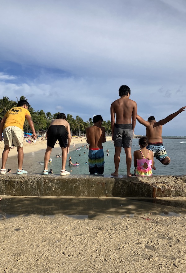 ワイキキビーチに飛び込むローカルの少年たち。